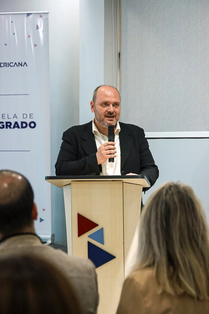 Giancarlo Prisco habla en el atril de la Escuela de Posgrado de la Universidad Americana