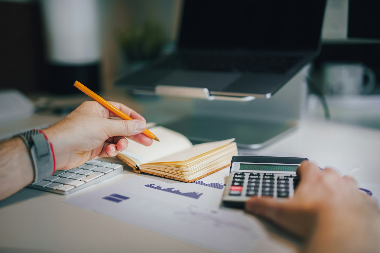 Persona organizando sus finanzas con una calculadora y un cuaderno