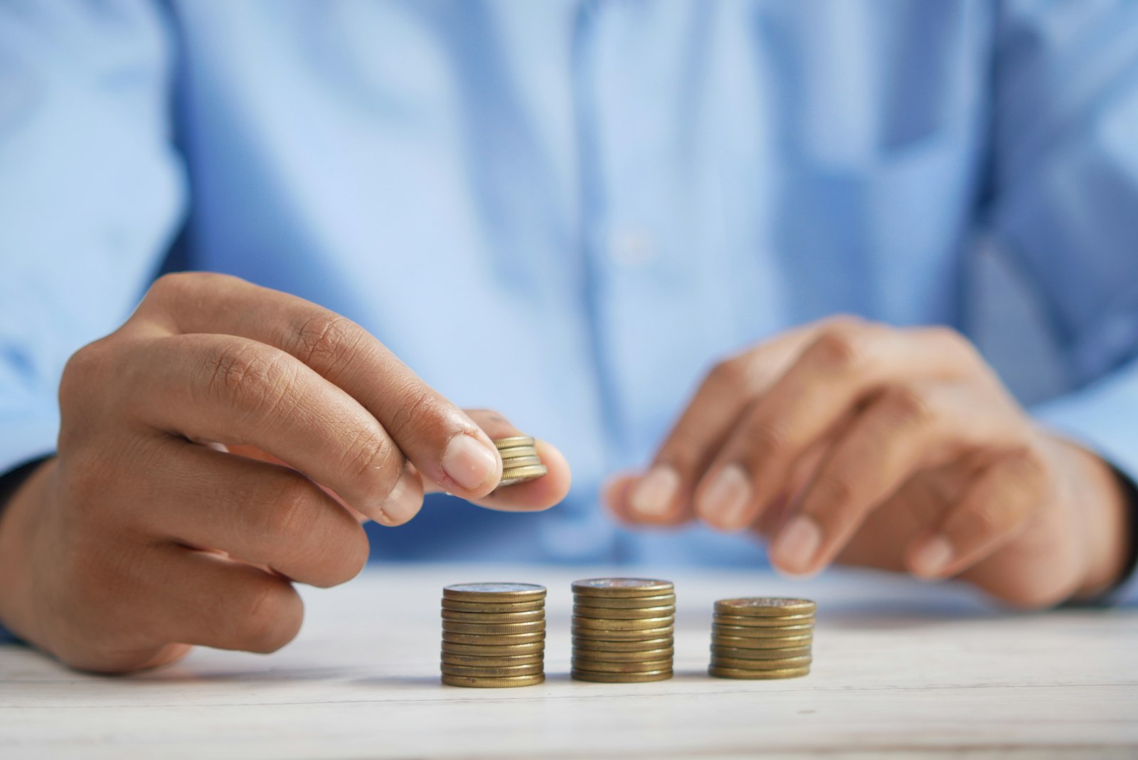 Persona apilando monedas sobre una mesa