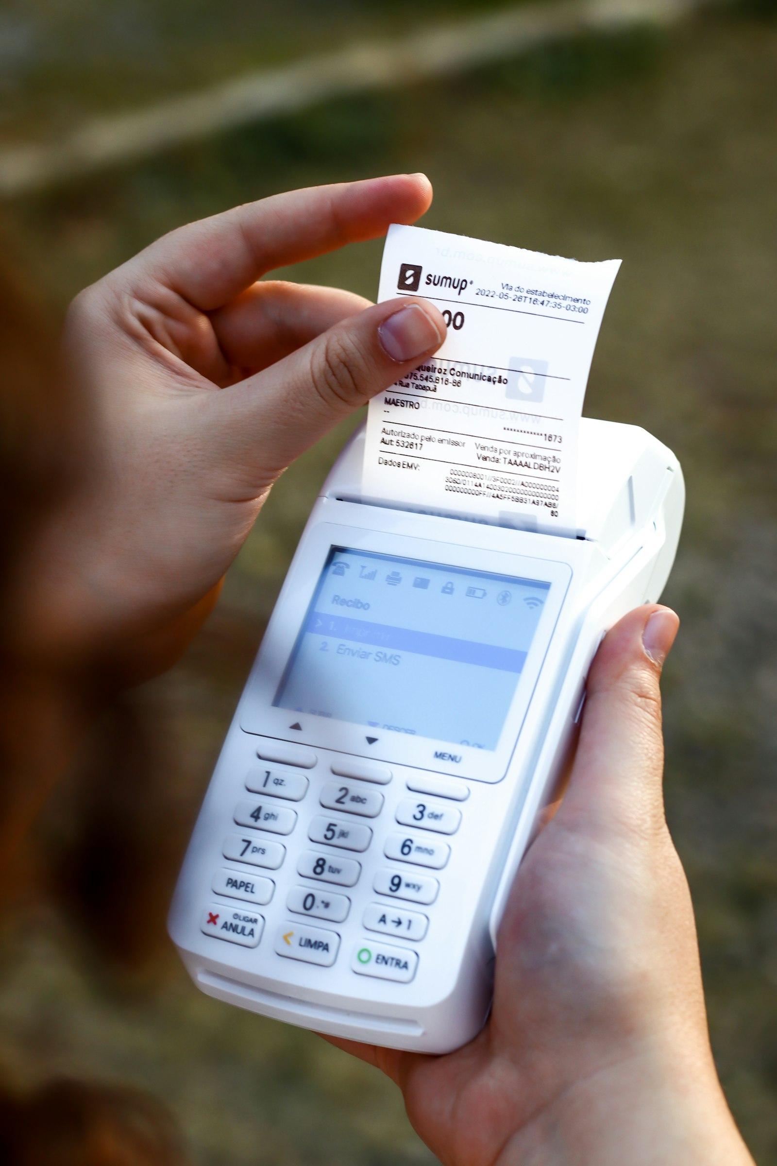 Persona con un ticket de compra y un teléfono en la mano