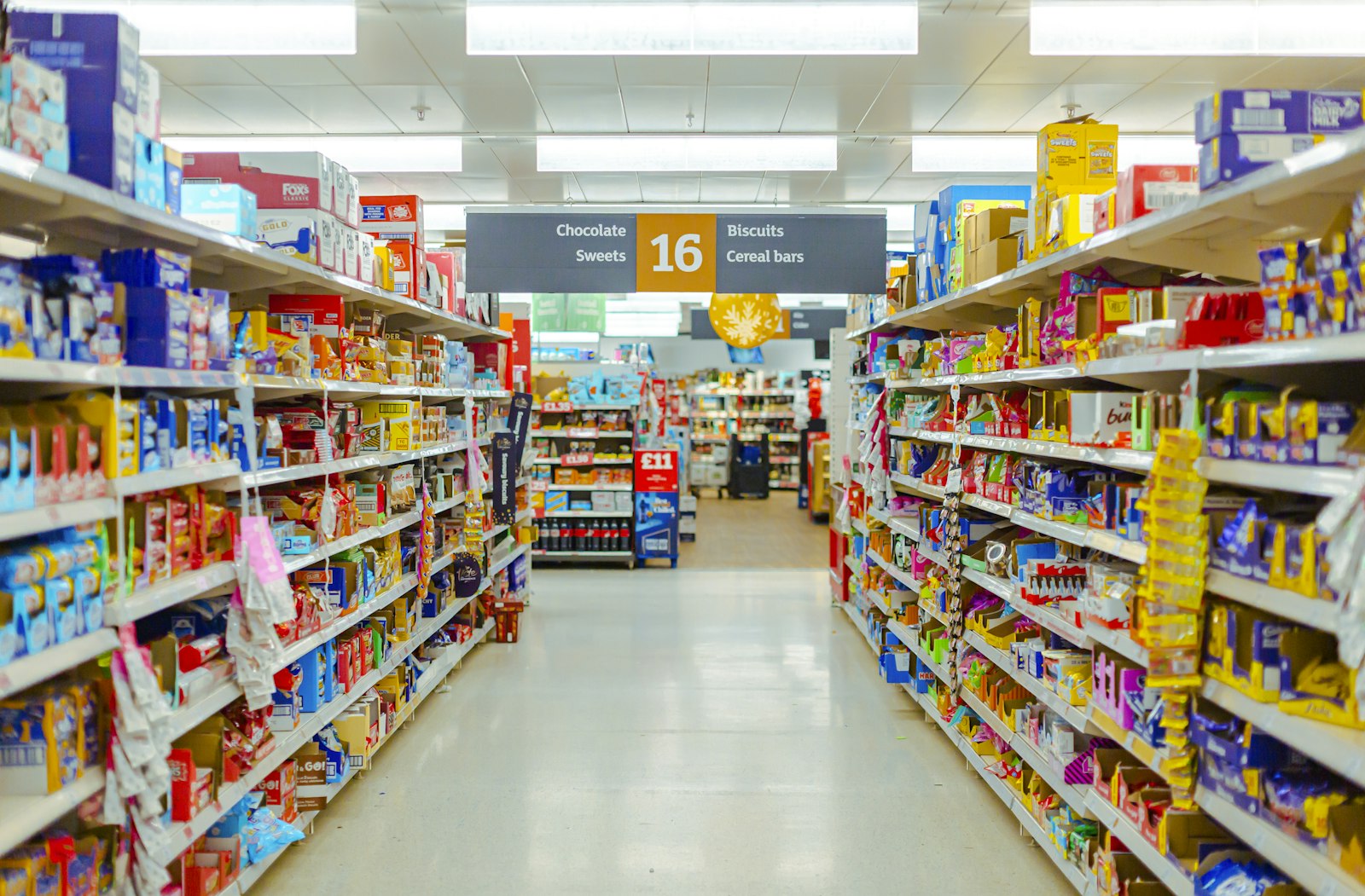 Pasillo de supermercado con estanterías llenas de productos